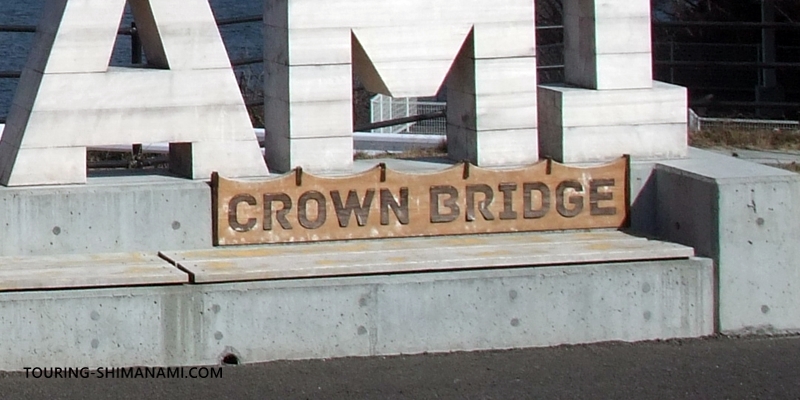 【写真】SHIMANAMI文字モニュメント：モニュメントにあるCROWN BRIDGEのロゴマーク